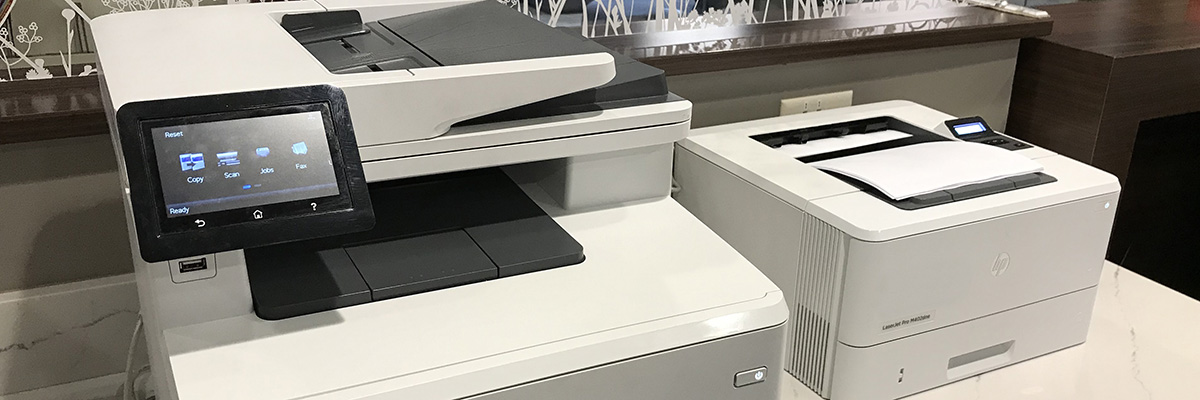Black & white and color printers printing documents at the library.