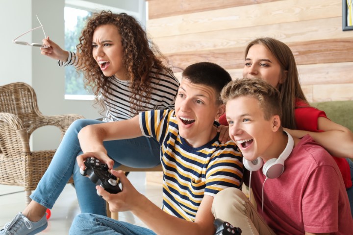 teenagers excitedly watching and playing a video game